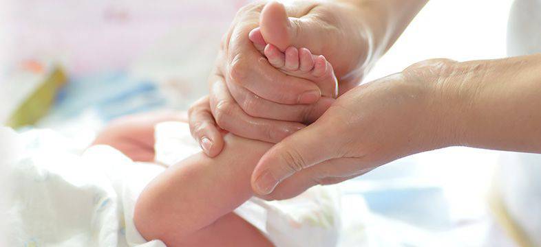 Manos sosteniendo los pies de un bebe
